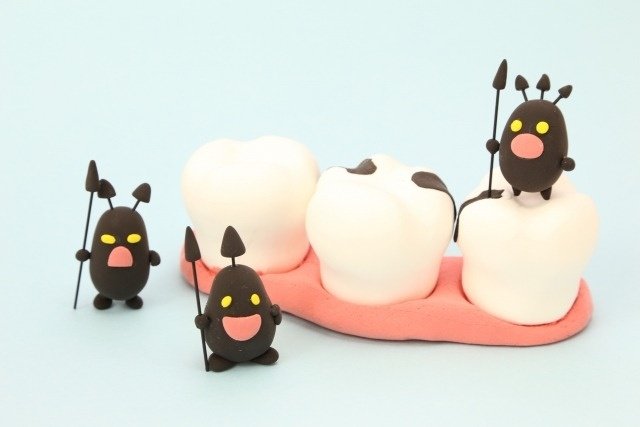 歯の模型に乗る虫歯のマスコット