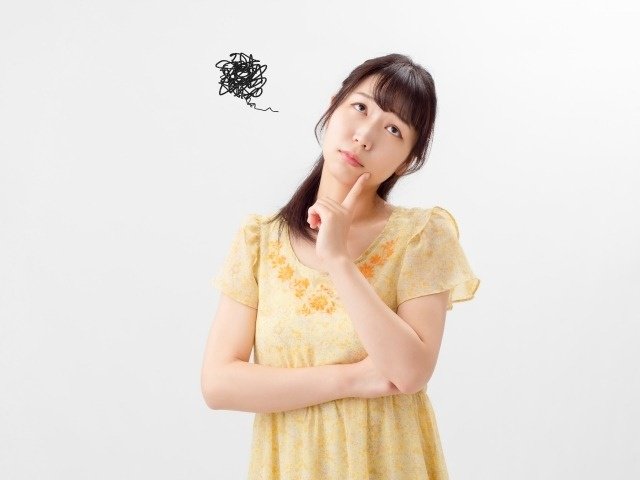 顎に指を添えて考える女性