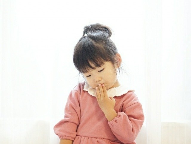 口元を抑える女の子