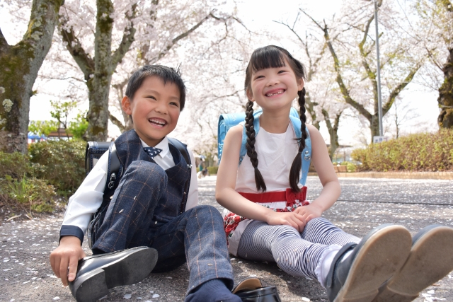 地面に座って笑っている男の子と女の子